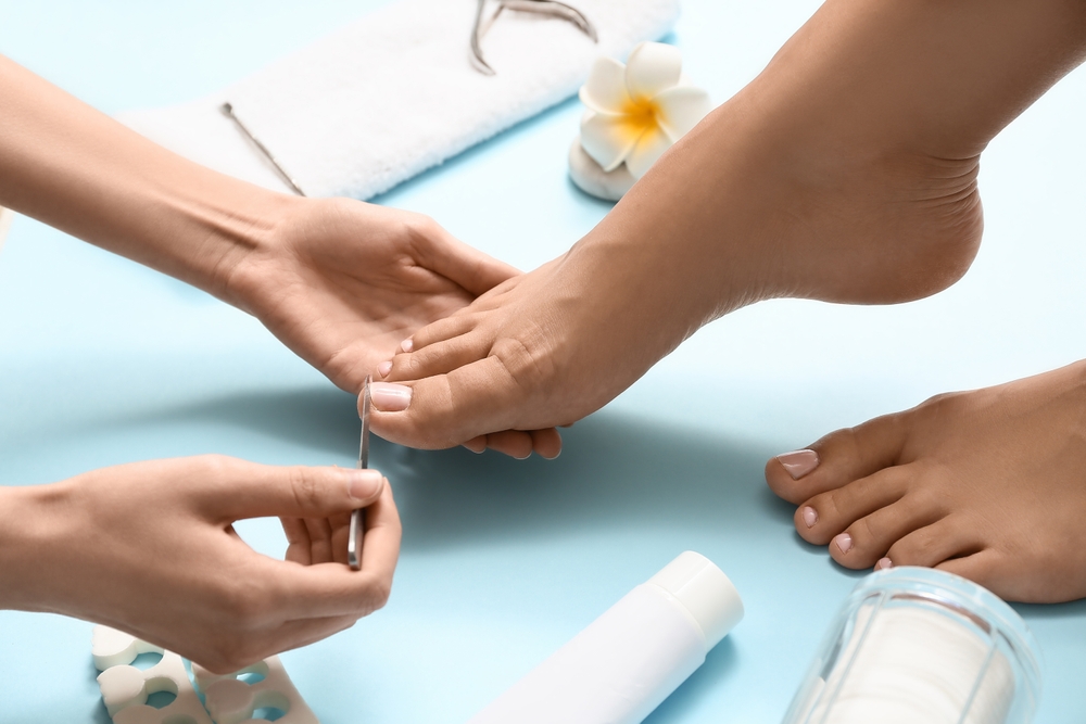 Young,Woman,Getting,Professional,Pedicure,With,Nail,File,On,Blue